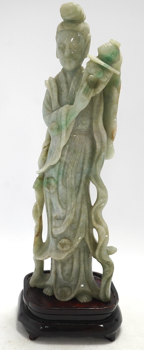 A Chinese jadeite carving of Guanyin, on associated hardwood stand, 38cm high. Condition - fair